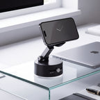 Black vacuum phone mount on glass desk with phone in landscape